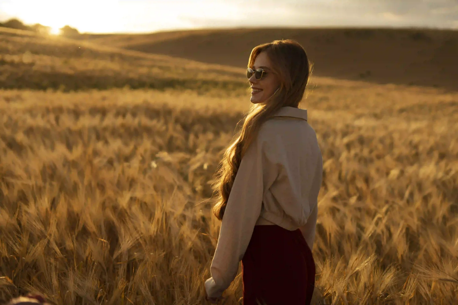 Woman in a wheat field lit by warm light during golden hour photography